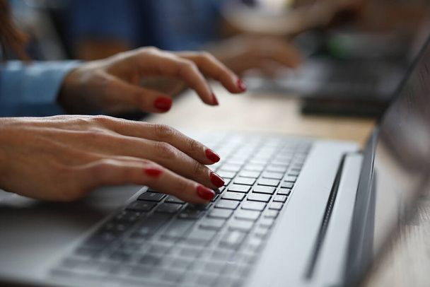 Woman with red nails is typing on keyboard. - Photo, image
