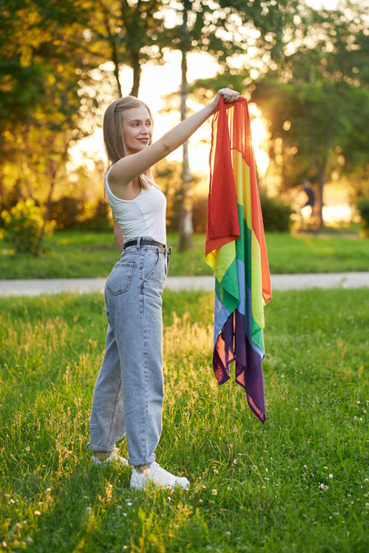 Smiling tolerant woman holding lgbt rainbow flag. - Fotó, kép