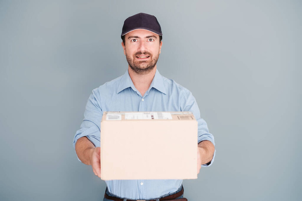 Delivery man holding package isolated on background - Photo, Image
