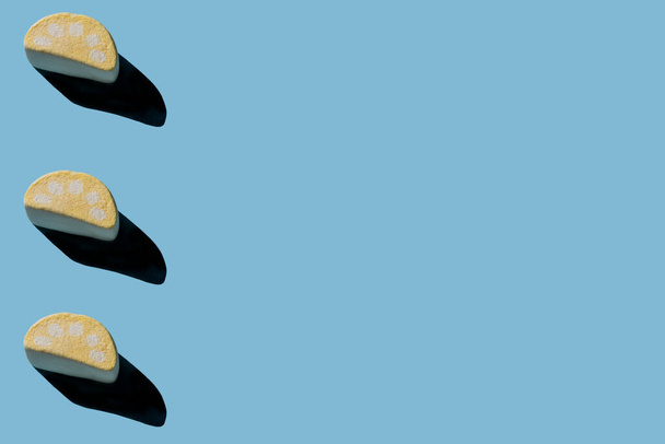 Plusieurs guimauves savoureuses avec des ombres dures sur un fond bleu clair avec espace de copie - Photo, image