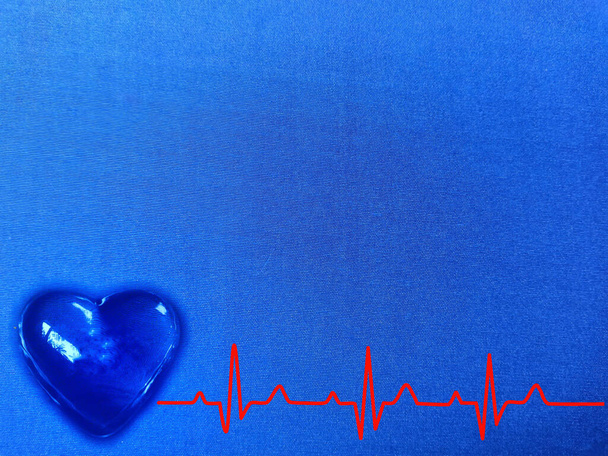 leuchtendes blaues Herz mit rotem Kardiogramm auf blauer Textur. - Foto, Bild