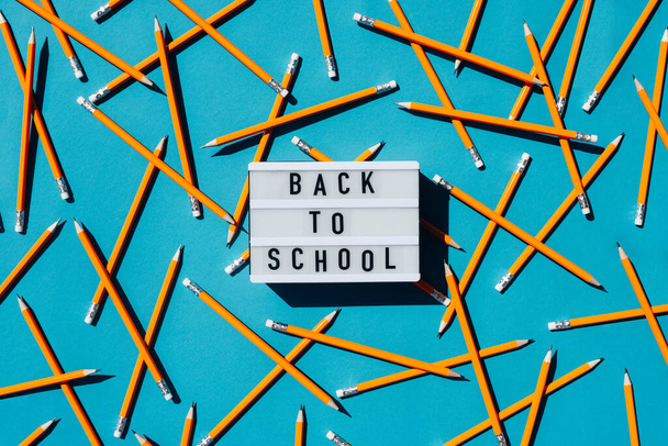 Background with simple pencils and the inscription back to school. School background. - Photo, Image