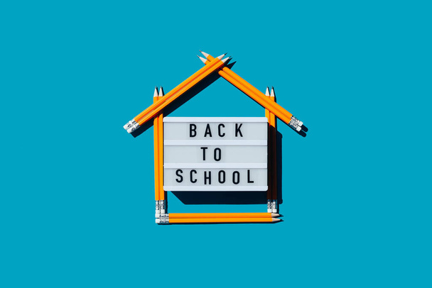 Lightbox with the inscription back to school and a house made of pencils. Home schooling. Distance learning. - Photo, Image