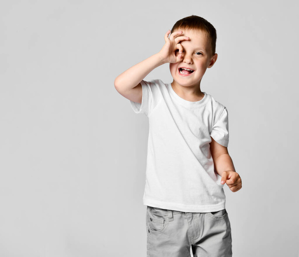 Boy looking through hands, making binoculars - Valokuva, kuva