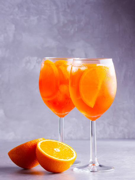 Aperol spritz cocktail on a gray background. Two glasses of aperol spritz with orange slised. Summer italian cocktail in glass. Copy space - Foto, Imagem