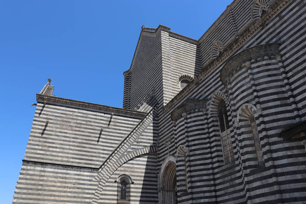 Katedra w Orvieto w stylu gotyckim. Prowincja Terni, Umbria, Włochy. Fasada zdobiona jest dużą serią płaskorzeźb. - Zdjęcie, obraz