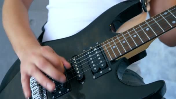 close up. hands of a male musician playing an electric guitar with a pick - Video