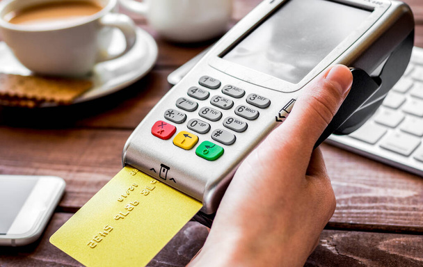 Payment for breakfast with card and terminal on wooden table background - Foto, Imagem