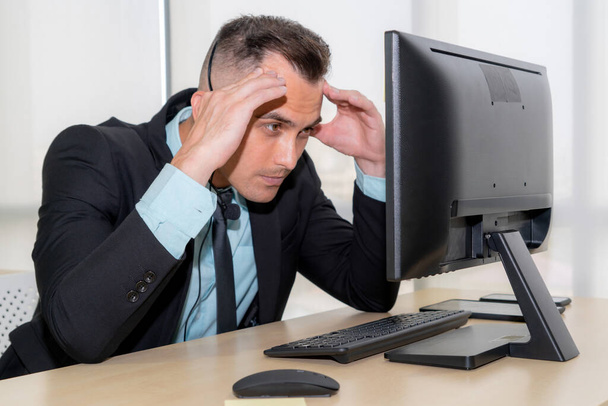 Gli uomini d'affari che indossano auricolari si sentono infelici lavorando in ufficio - Foto, immagini