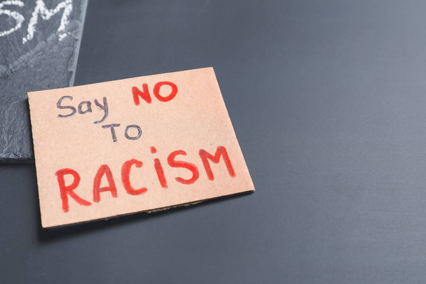 Plaque avec texte SAY NO RACISM sur fond sombre - Photo, image