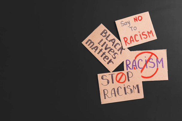 Carteles diferentes sobre fondo oscuro. Detener el racismo
 - Foto, Imagen