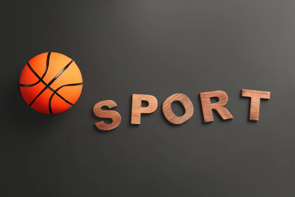Koyu arkaplanda Spor sözcüğüyle basketbol oynamak için top - Fotoğraf, Görsel