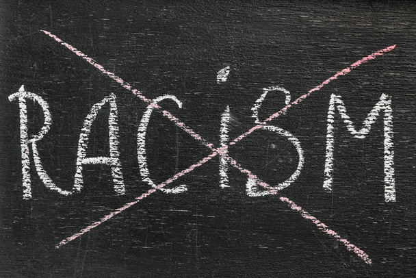 Tablica z wykreślonym słowem RACISM, zbliżenie - Zdjęcie, obraz