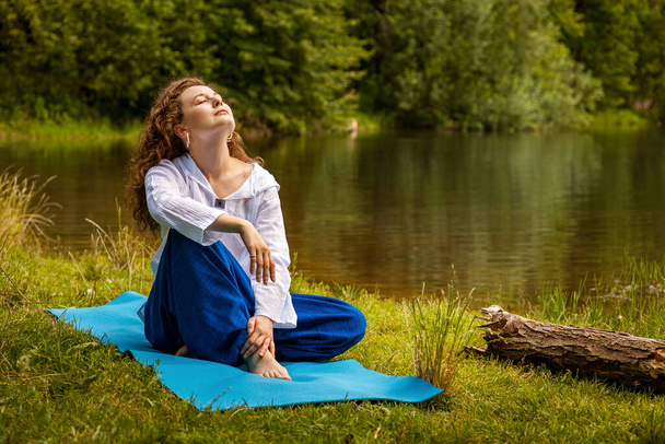 A menina pratica ioga junto ao lago
. - Foto, Imagem
