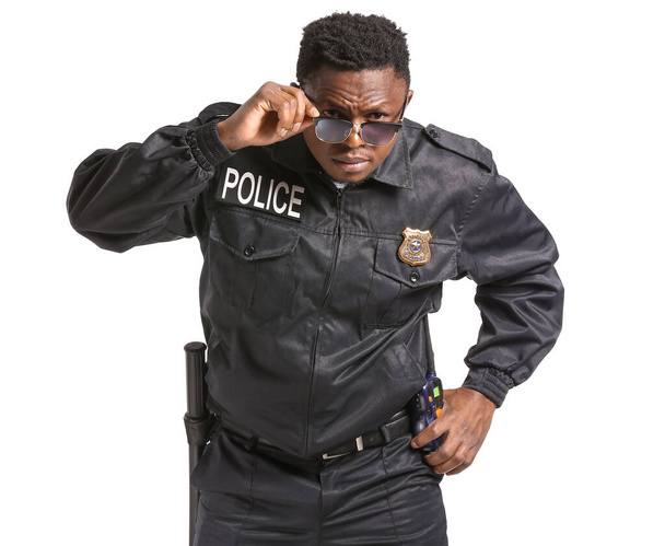 Aggressive African-American police officer on white background - Foto, Imagen