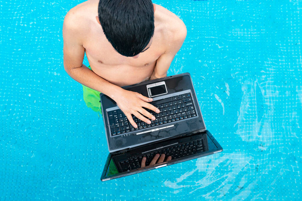 homme avec ordinateur portable dans la piscine - Photo, image