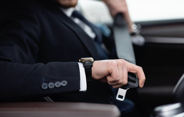 Business Man Putting On Seat Belt Sitting In His Car - Foto, Bild