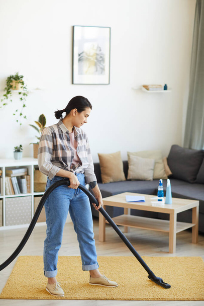 Woman vacuuming the carpet - Foto, Imagen