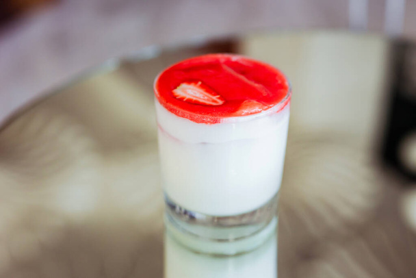 A creamy cocktail with strawberry foam on top, served in a rocks glass - Foto, Imagem