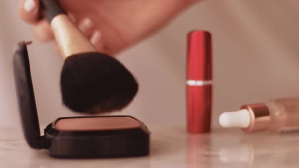 Tyylikkäät meikkivalmisteet marmoripöydällä, jauheella, huulipunalla ja harjalla kosmetiikka- ja kauneusmerkin taustana - Materiaali, video