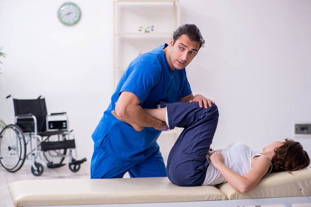 Injured woman visiting young male doctor osteopath - Foto, imagen
