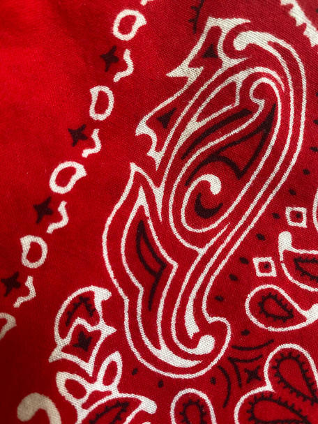 Крупный план хлопчатобумажной ткани красной банданы, для использования в качестве покрытия лица во время пандемии коронавируса
. - Фото, изображение