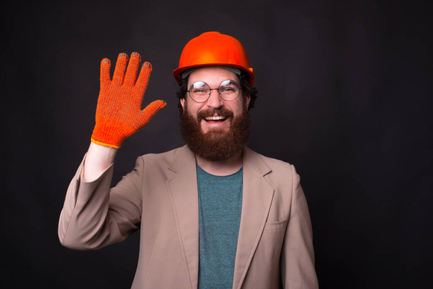 Photo of happy architect worker making Hello gesture and smiling - Photo, Image