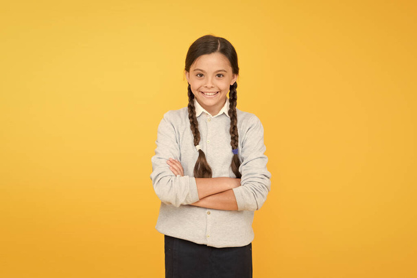 Congratulations. smart little girl on yellow background. knowledge day. childhood happiness. education concept. back to school. happy girl in school uniform. kid fashion. school market - Photo, image