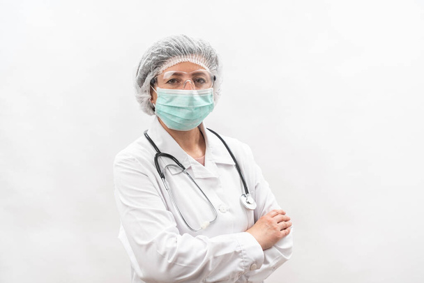 Tired female medic, nurse in protective equipment and a mask from viruses, on a white background. With a stethoscope. - Photo, image