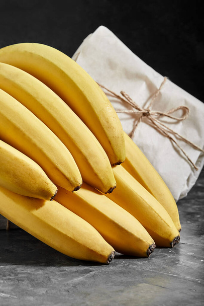 Μπανάνες απομονωμένες σε γκρι φόντο τσιμέντου - Φωτογραφία, εικόνα