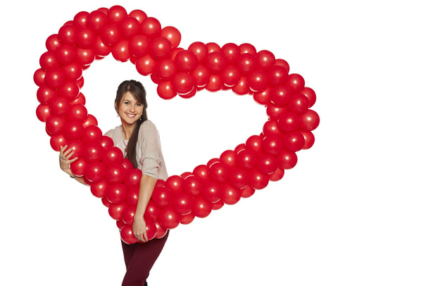 Smiling woman holding red balloon heart - Fotografie, Obrázek