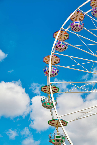 Grande roue par une journée ensoleillée avec ciel bleu et nuages en arrière-plan. - Photo, image