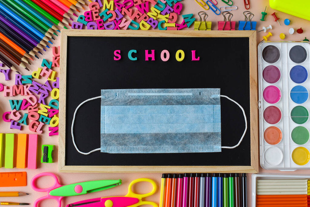 Back to school Stationery and a blackboard with a mask. Coronavirus pandemic. - Foto, Imagen
