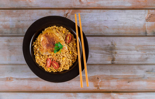 Ζυμαρικά και ρύζι με κοτόπουλο και λαχανικά σε μαύρο μπολ. Ασιατική κουζίνα. - Φωτογραφία, εικόνα