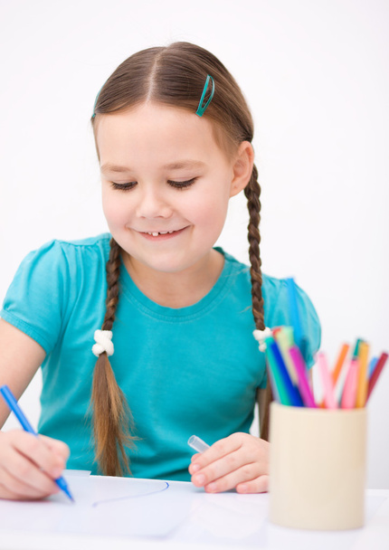 Pieni tyttö piirtää käyttäen kyniä
 - Valokuva, kuva