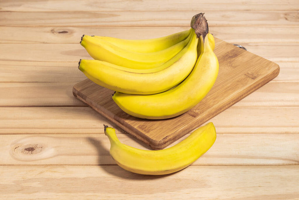 Bunch of bananas  on wooden table - Фото, зображення