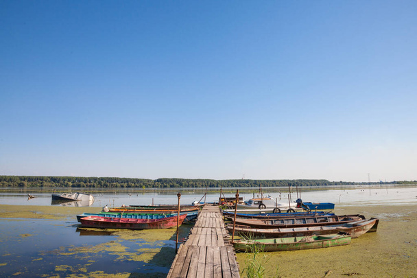 Παλιές βάρκες αγκυροβολούν σε ερειπωμένο πλωτό στον ποταμό Δούναβη στη Σερβία, κατά τη διάρκεια ηλιόλουστου απογεύματος. Ο Δούναβης είναι ο μεγαλύτερος ποταμός της Κεντρικής Ευρώπης - Φωτογραφία, εικόνα