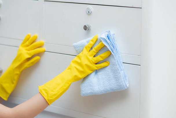 Closeup hand of young asian woman in gloves cleaning home in room, housekeeper is wipe with fabric, housemaid and service, worker polish dust in house, housework and domestic, lifestyle concept. - Photo, Image