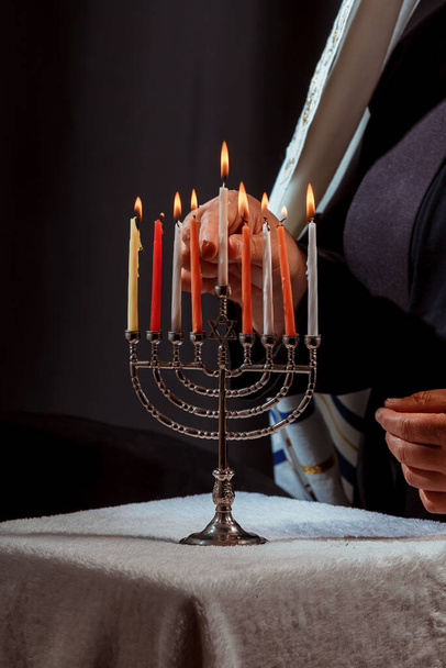 Muž ruka zapalování svíčky v menorah pro hanukka světla svíčky - Fotografie, Obrázek