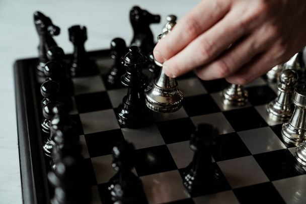 Mano de hombre de negocios jugar con el juego de ajedrez. concepto de estrategia y táctica empresarial
. - Foto, imagen