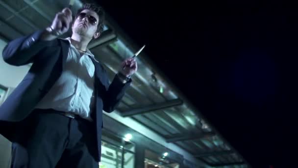 Чоловік з сонцезахисними окулярами грає посудини з барабанними паличками вночі у повільному темпі
 - Кадри, відео