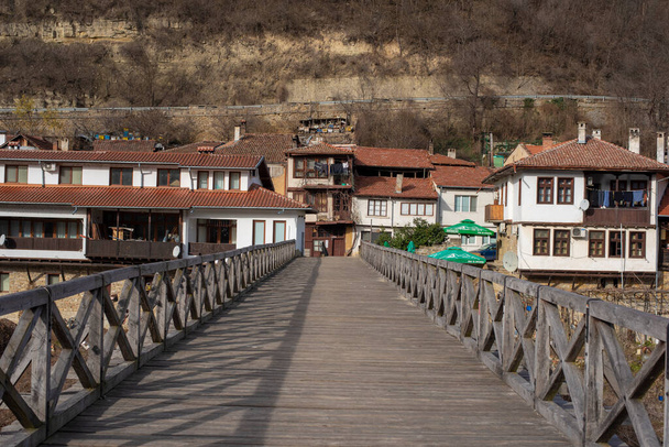 Veliko Tarnovo, Болгарія - 12 березня 2019: панорамний вид на район Асеново. Дерев'яний пішохідний міст Владишкі через річку Янтра і старі будинки. Панорама - Фото, зображення
