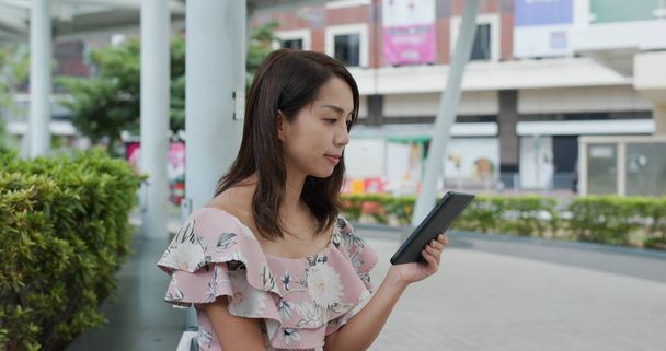 Vrouw lees boek over elektronische lezer bij outdoor  - Foto, afbeelding