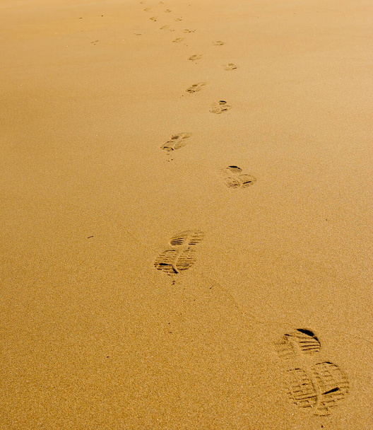 Следы человека в желтом песке на пляже
 - Фото, изображение