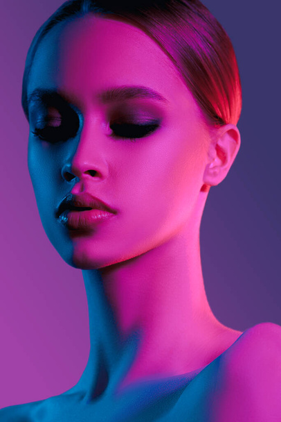 Fashion colorful beauty makeup portrait. Beautiful model girl. Neon lights studio woman closeup portrait - Fotó, kép