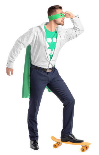 Человек, одетый как эко-супергерой со скейтбордом на белом фоне
 - Фото, изображение