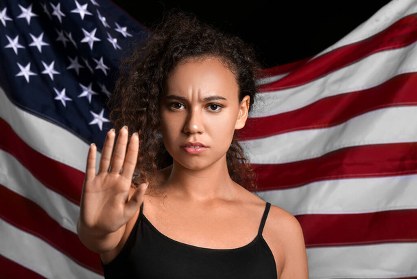 アメリカ国旗に反対するアフリカ系アメリカ人女性。人種差別をやめ - 写真・画像