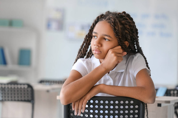 Λυπημένη Αφρο-Αμερικανίδα στο σχολείο. Σταματήστε τον ρατσισμό - Φωτογραφία, εικόνα