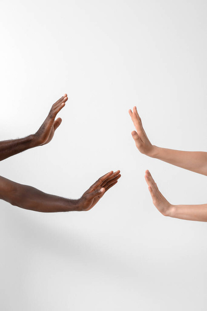 Hands of Caucasian woman and African-American man on light background. Racism concept - Photo, Image