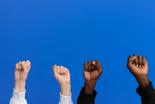 Кавказька жінка і афро-американський чоловік з стиснутими кулаками на кольоровому тлі. Концепція расизму - Фото, зображення